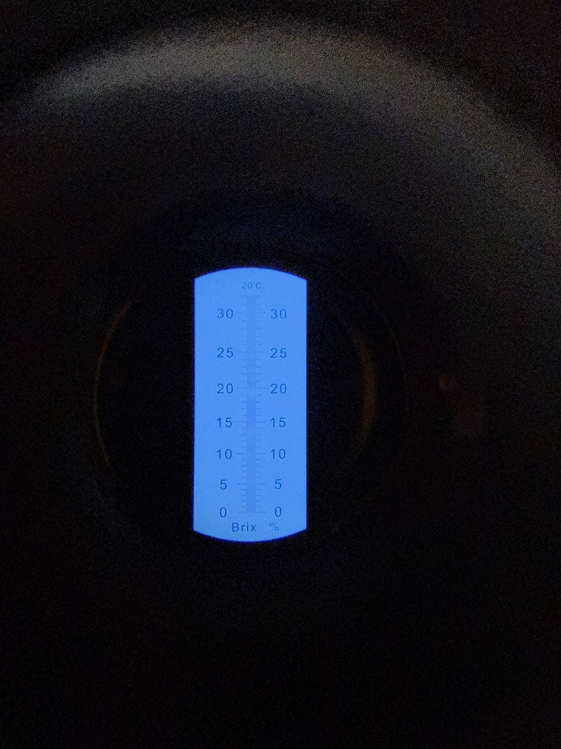 View through refractometer eyepiece showing the Brix percent scale